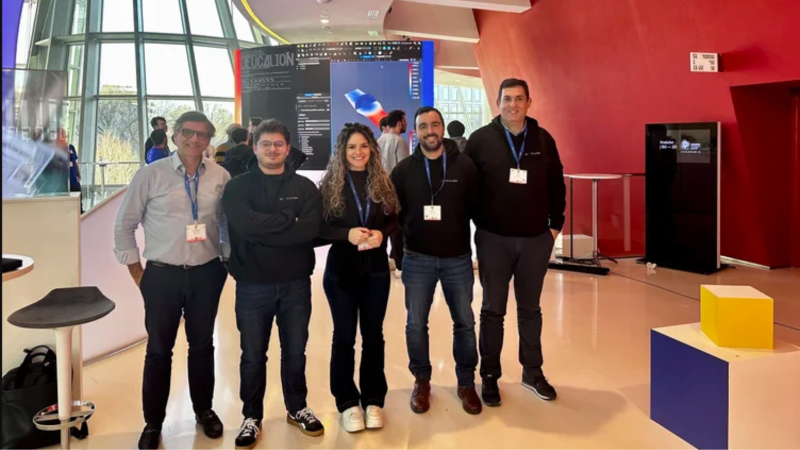 Four men and one woman, Deucalion researchers, standing in a conference room.