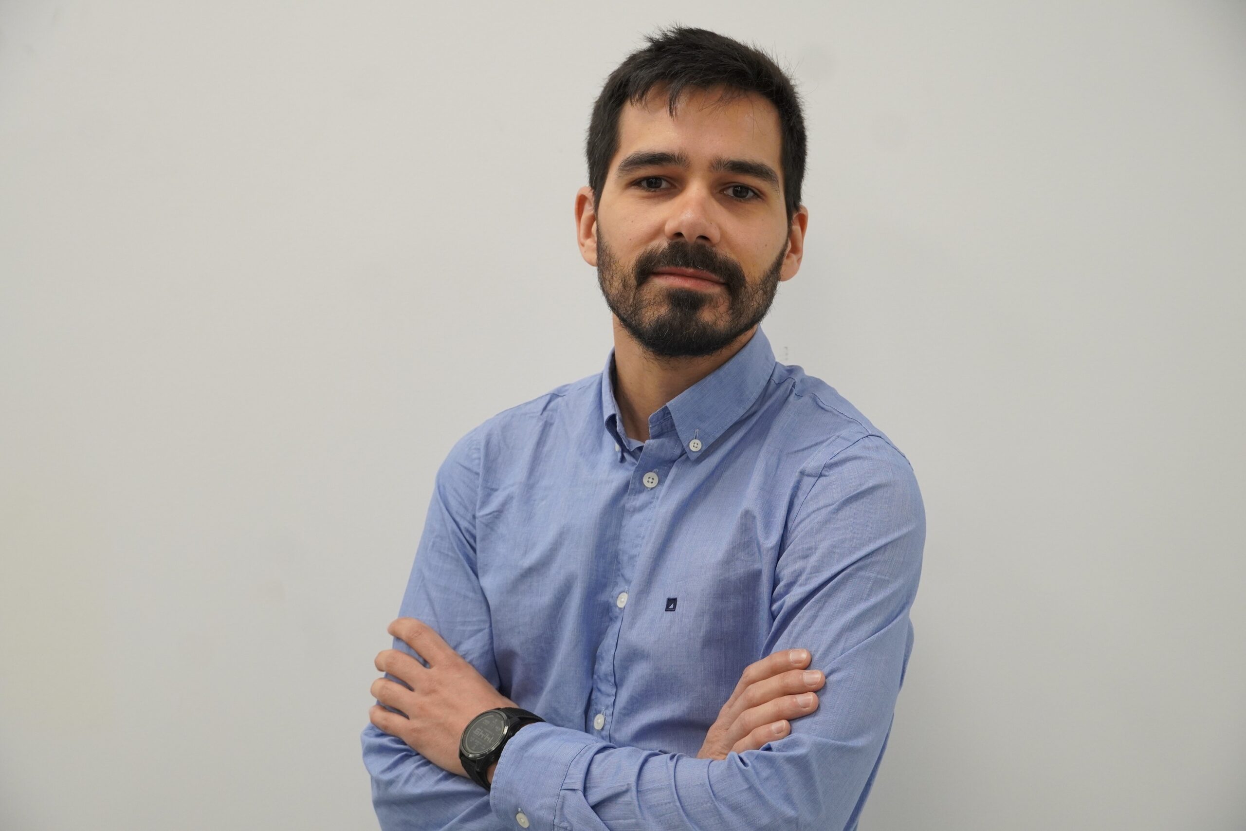 Man wearing a blue shirt with arms-crossed.