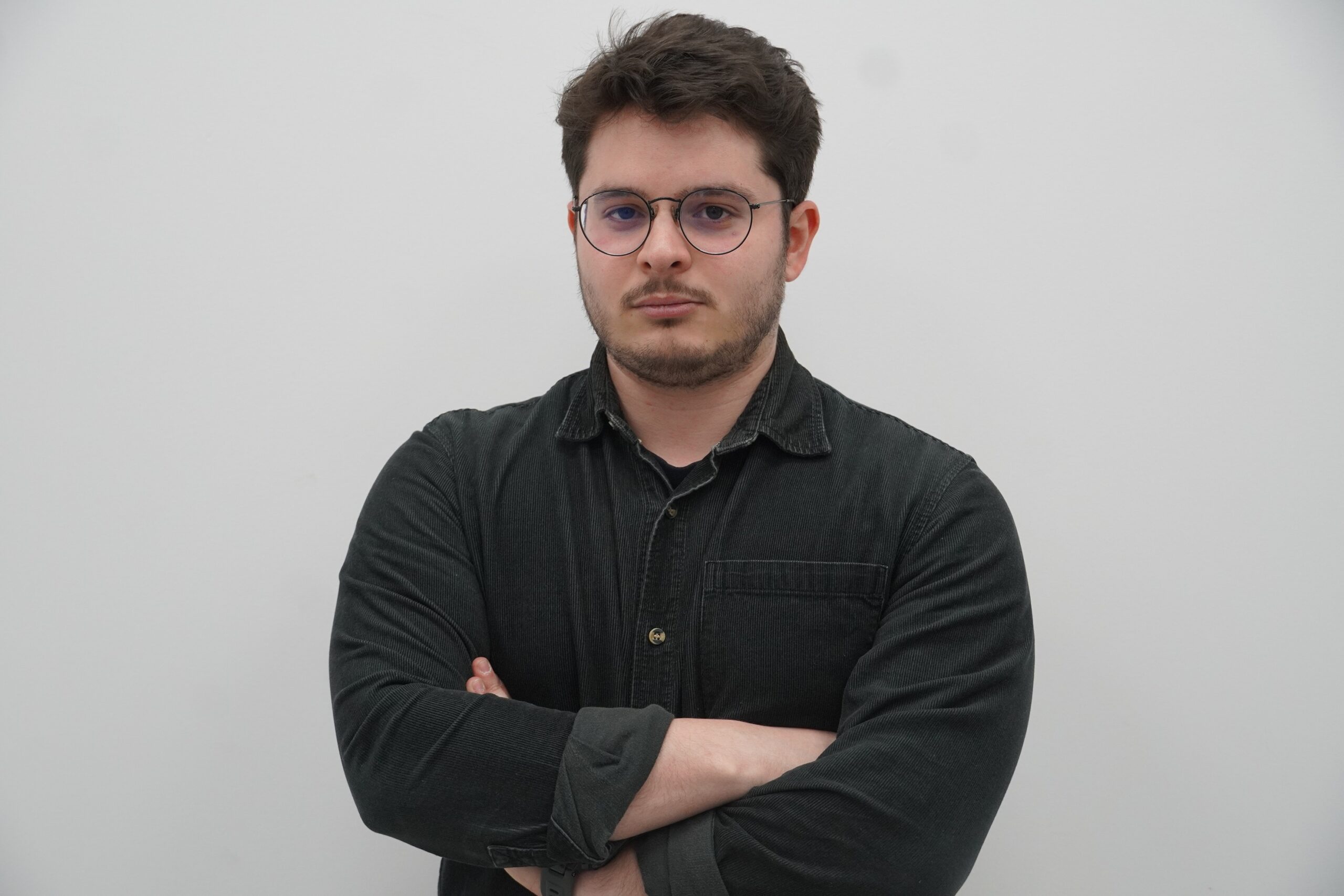 Man wearing a black shirt with arms-crossed.
