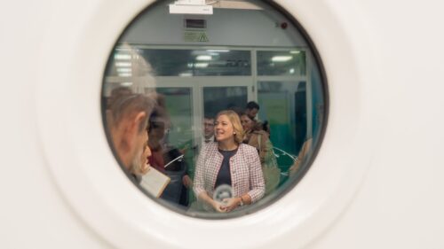View through circular window showing Henna Virkkunen speaking with researchers inside the Deucalion supercomputing facility.