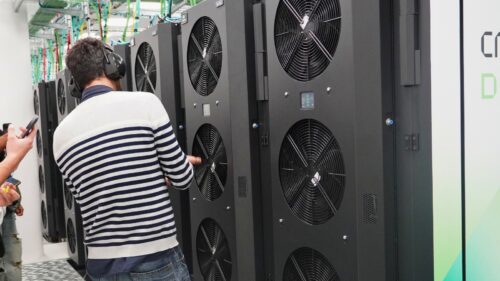 A male researcher pointing to ventilation of a supercomputer.