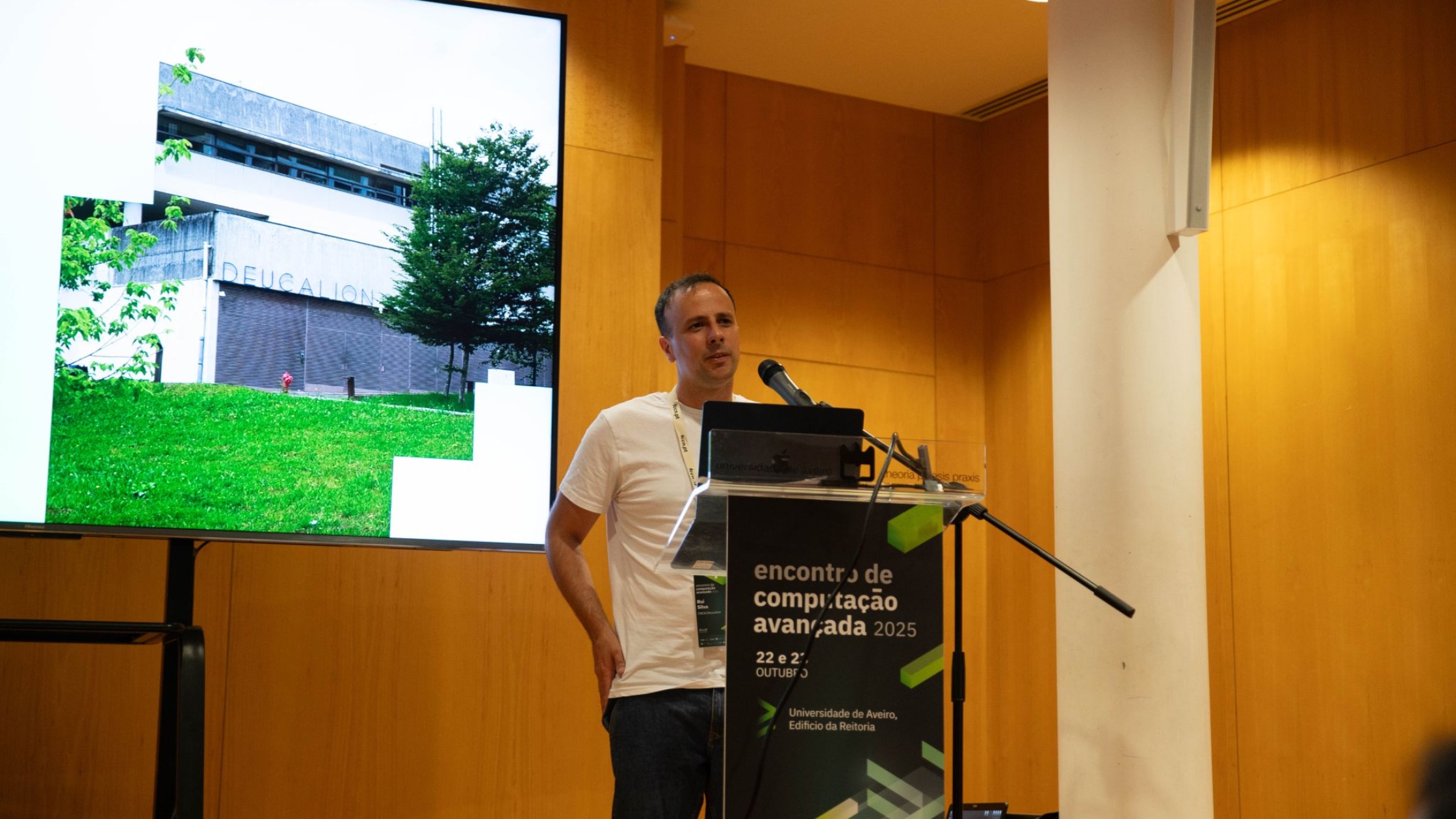 Researcher presenting the Deucalion supercomputer at the Encontro de Computação Avançada 2025, with a photo of the Deucalion facility shown on screen.