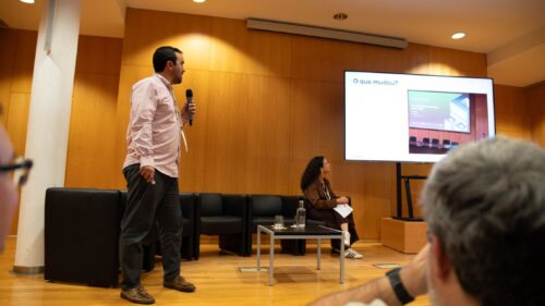 Speaker presenting Deucalion updates during the Encontro de Computação Avançada 2025, with slides displayed on a large screen.