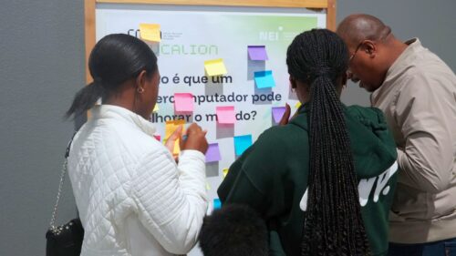 Participants place sticky notes on a board asking “What can a supercomputer improve in the world?”, encouraging public engagement and reflection on the impact of high-performance computing.