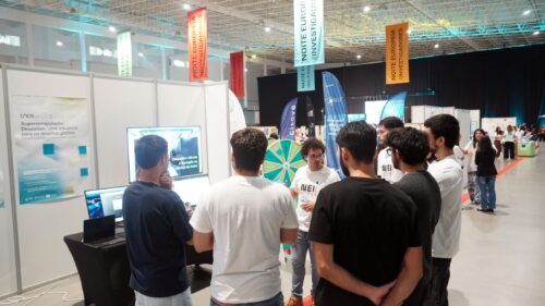 Interactive demonstration of Deucalion on a large screen, with a researcher explaining the supercomputer’s capabilities to a group of young visitors.