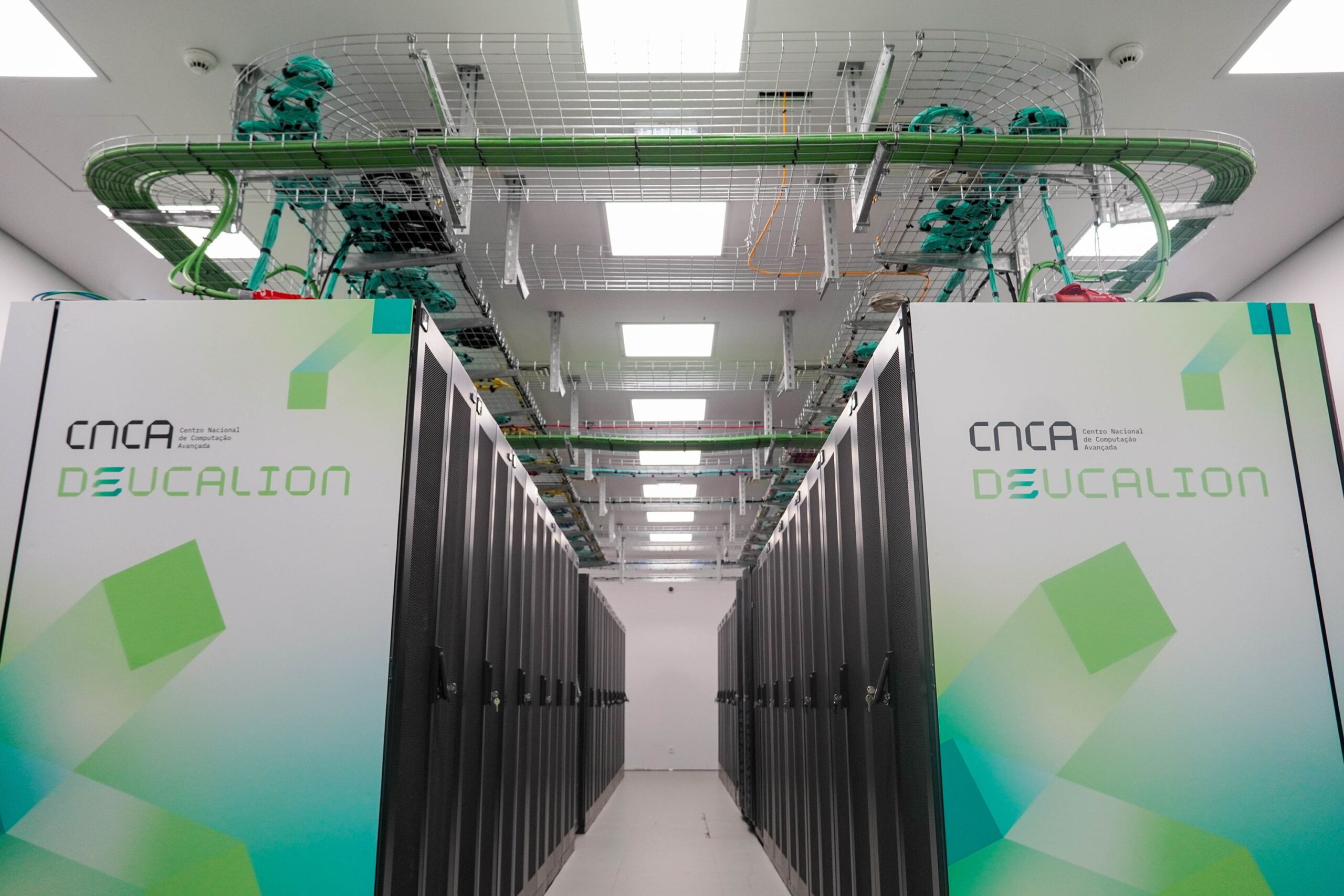 Deucalion supercomputer racks inside a data centre, showing rows of black server cabinets and cooling units with the Deucalion branding on the front panels.