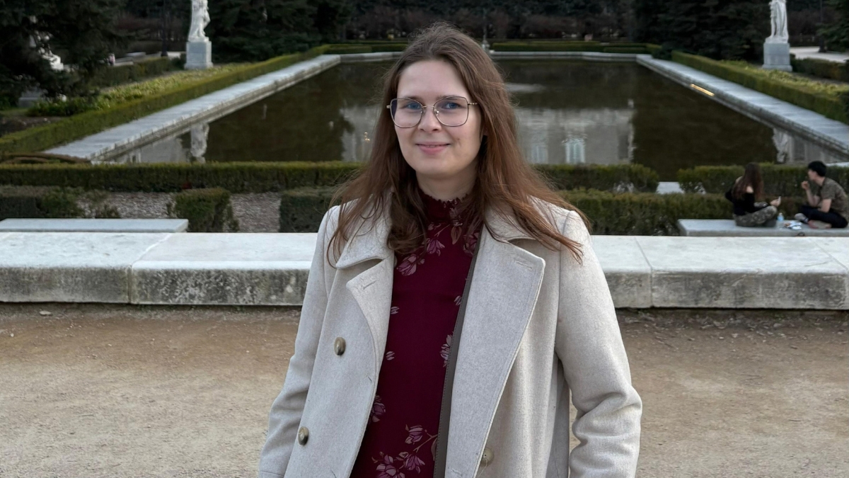 Woman standing in front of a pond.