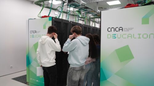 Estudantes ao lado das racks dos servidores do supercomputador Deucalion dentro de um centro de dados, durante uma visita guiada.