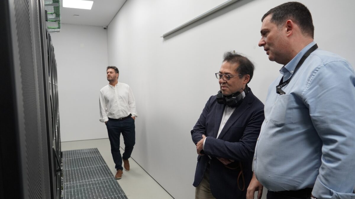 Homem a examinar servidores de rack e a falar durante uma visita técnica em Portugal.